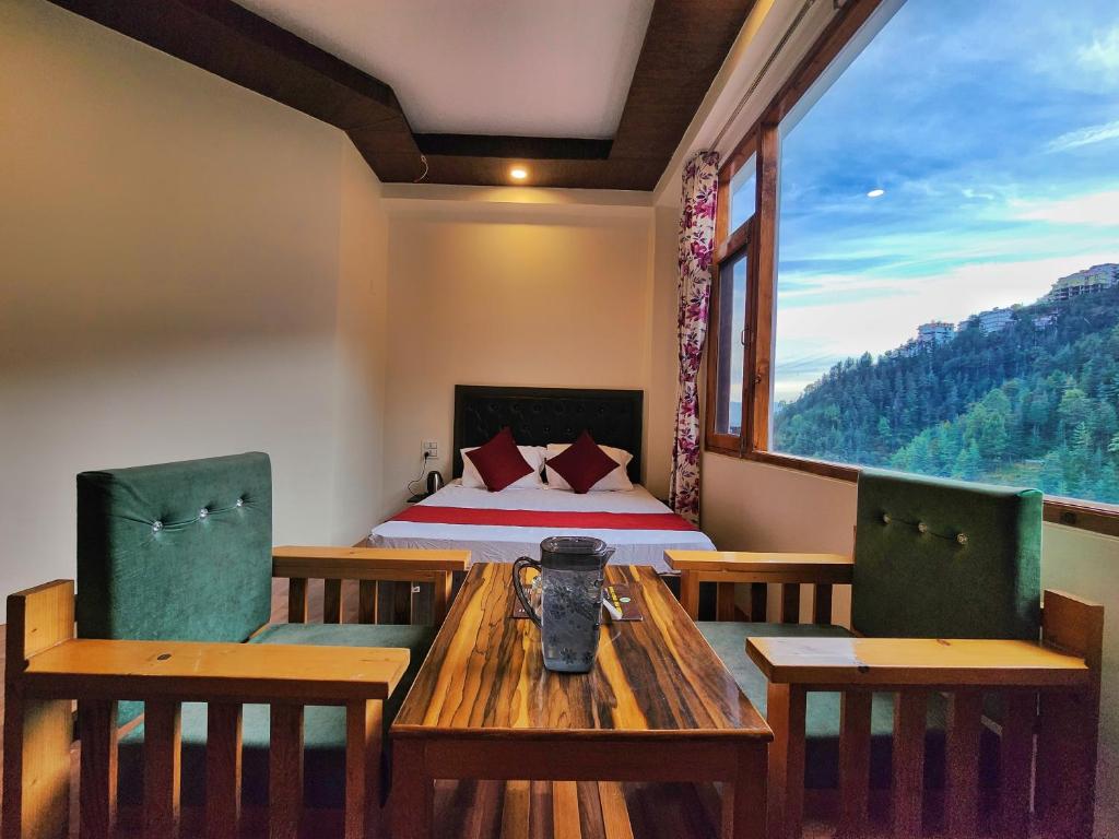 a room with a bed and a table and chairs at Hotel Royal Cedar Simla in Shimla