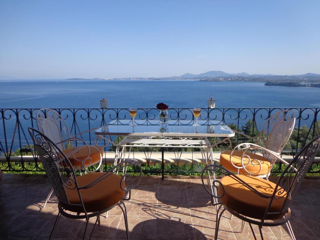 PyrgiにあるVilla Pergolaのテーブルと椅子、水辺の景色を望むバルコニー