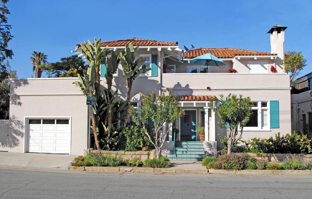 a white house with palm trees in front of it at Casa Azzurra in Santa Barbara