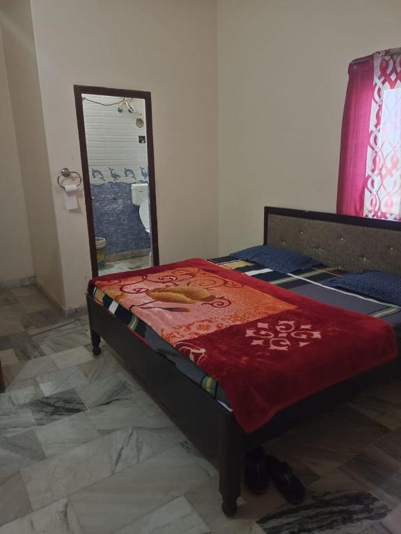 a bed sitting in a room with a mirror at Mahadev hotel bambor in Jodhpur