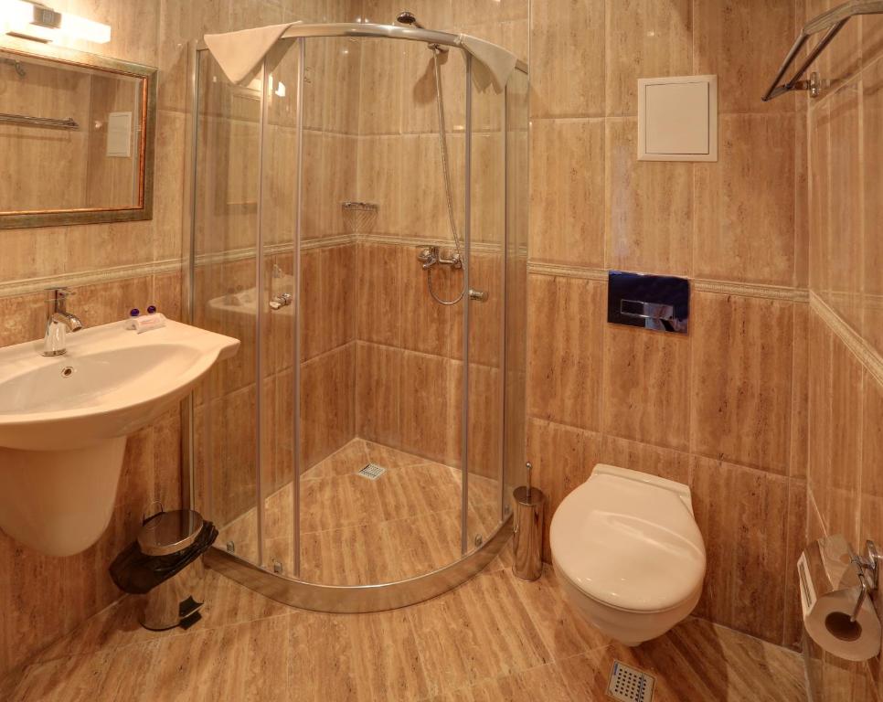 a bathroom with a shower and a toilet and a sink at Paraiso Theopolis - All Inclusive in Obzor