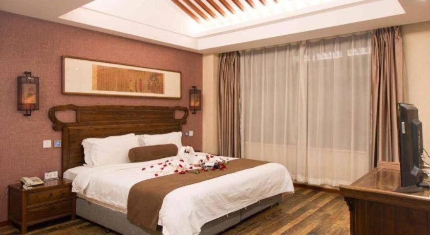 a bedroom with a large bed with roses on it at James Joyce Coffetel Xian Dayanta Metro Station Branch in Xi'an