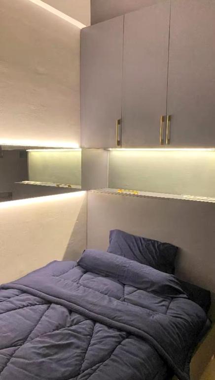 a bedroom with a bed and a kitchen with cabinets at Kryvon Studio Apartment in Leuweungmalang