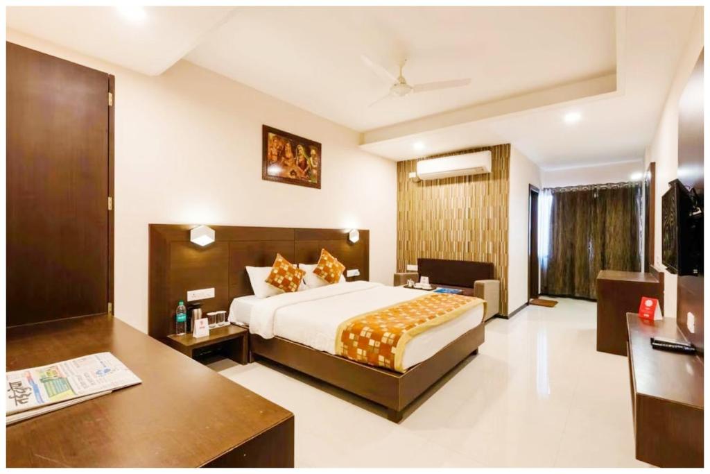 a hotel room with a bed and a desk at Hotel Shriniwash Residency Near Shri Mahakaleshwar Jyotirlinga Temple in Ujjain