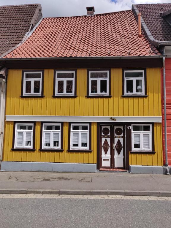 a yellow house with white windows and a red roof at Haus-Salamander-mit-Sauna in Wildemann