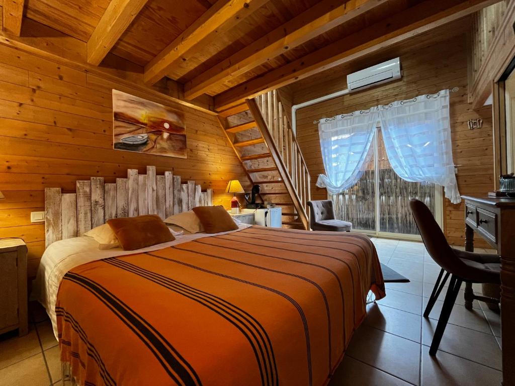 Un dormitorio con una cama y un escritorio y una ventana. en Villa Herbert Hôtel, en Andernos-les-Bains