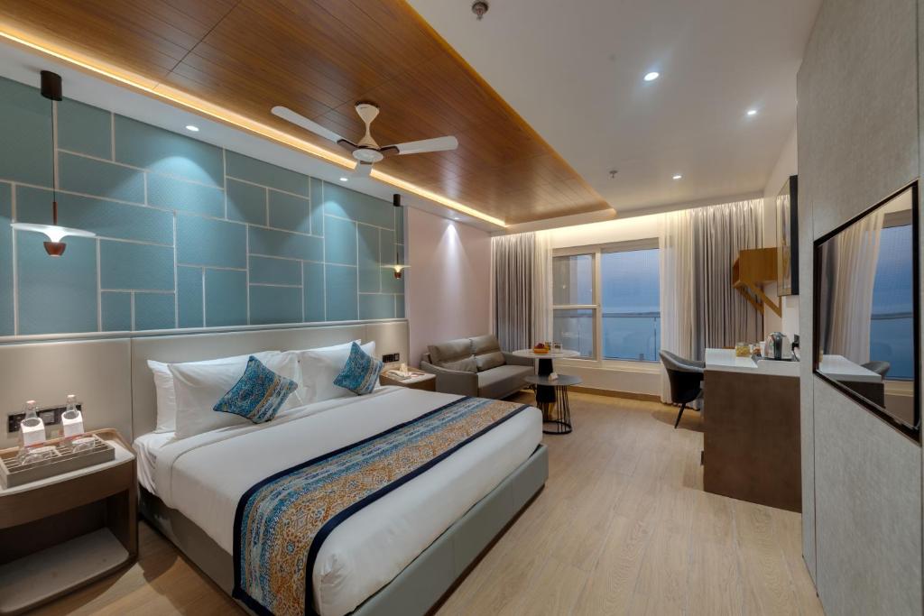 a hotel room with a large bed and a desk at Ira by Orchid Dwarka in Dwarka