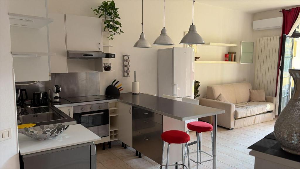 een keuken met een aanrecht en rode krukken. bij La casa di Mery Sun in Milaan