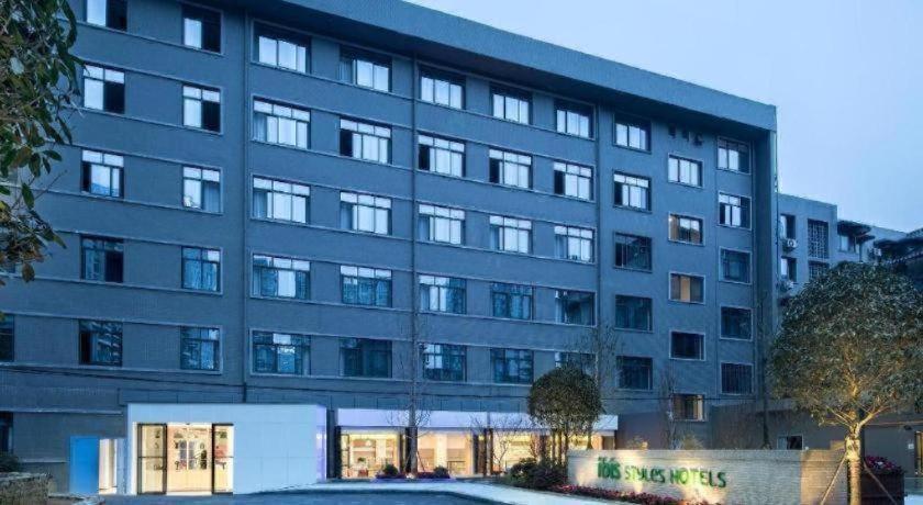 a large building with a parking lot in front of it at Ibis Styles Chengdu Chunxi Taikoo Li Hotel in Chengdu
