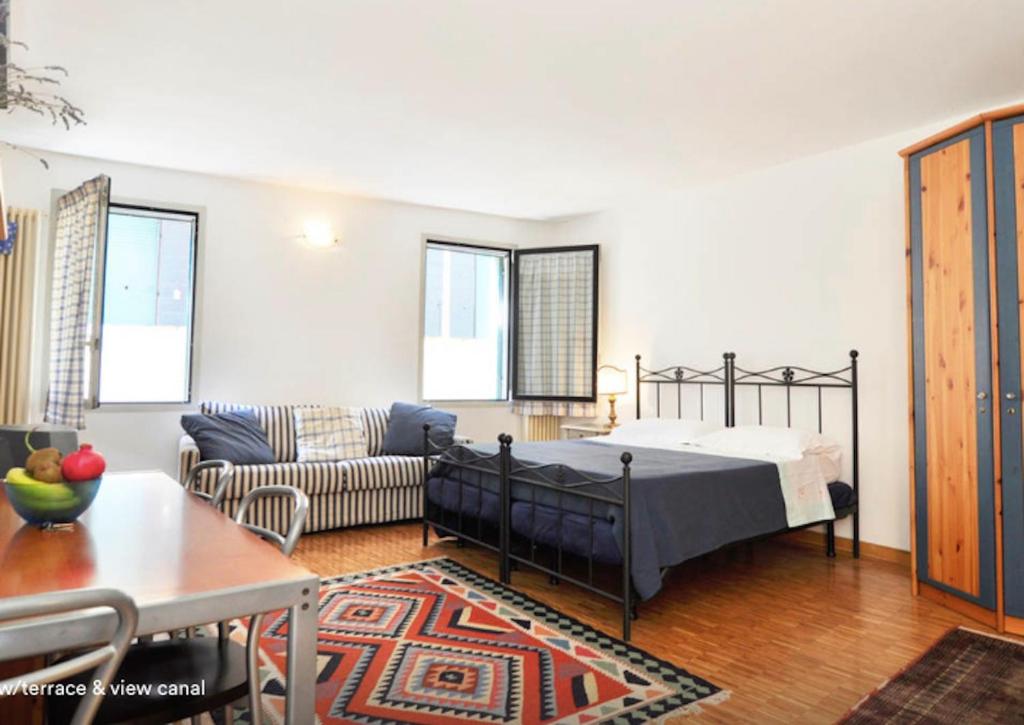 a bedroom with a bed and a living room at San Rocco Apartment in Venice