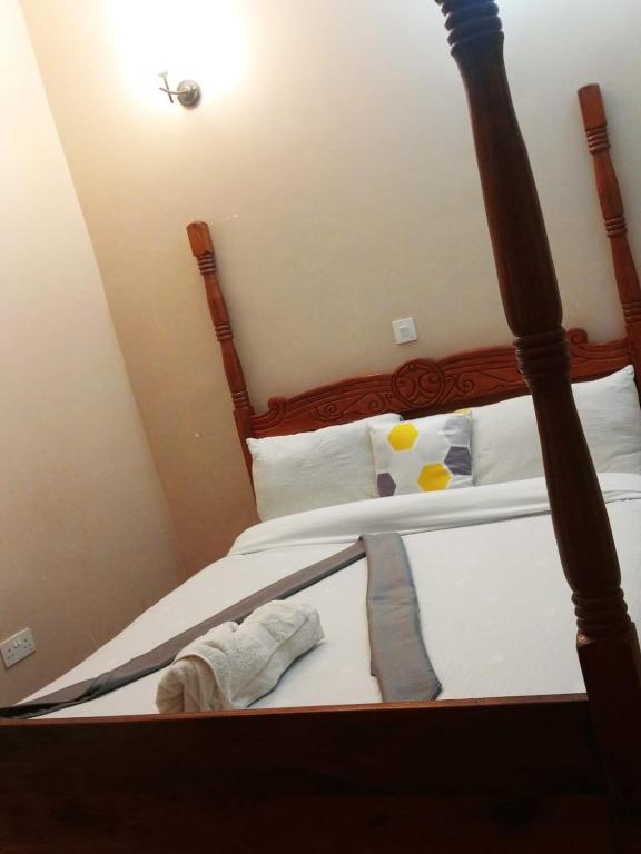 ein Schlafzimmer mit einem Bett mit einem Bettrahmen aus Holz in der Unterkunft Villa serene hotel kitale in Kitale