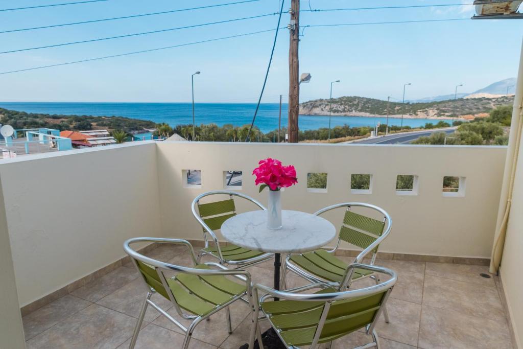 a table with chairs and a vase of flowers on a balcony at Vrokastro Apartments in Istro