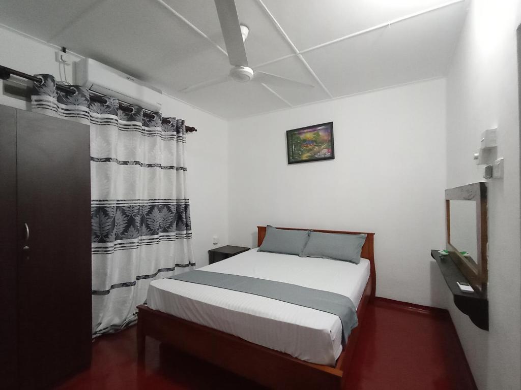 a bedroom with a white bed and a window at Bee Cottage Negombo in Negombo
