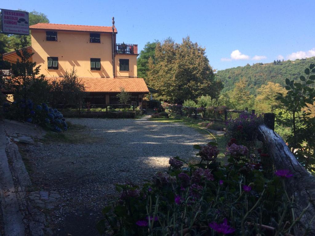 a house with a garden and flowers in front of it at Agriturismo LA TAVERNA DEL NONNO in Borzonasca
