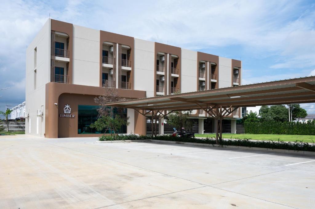 a large building with a parking lot in front of it at Timber Hotel in Ban Bang Rathuk