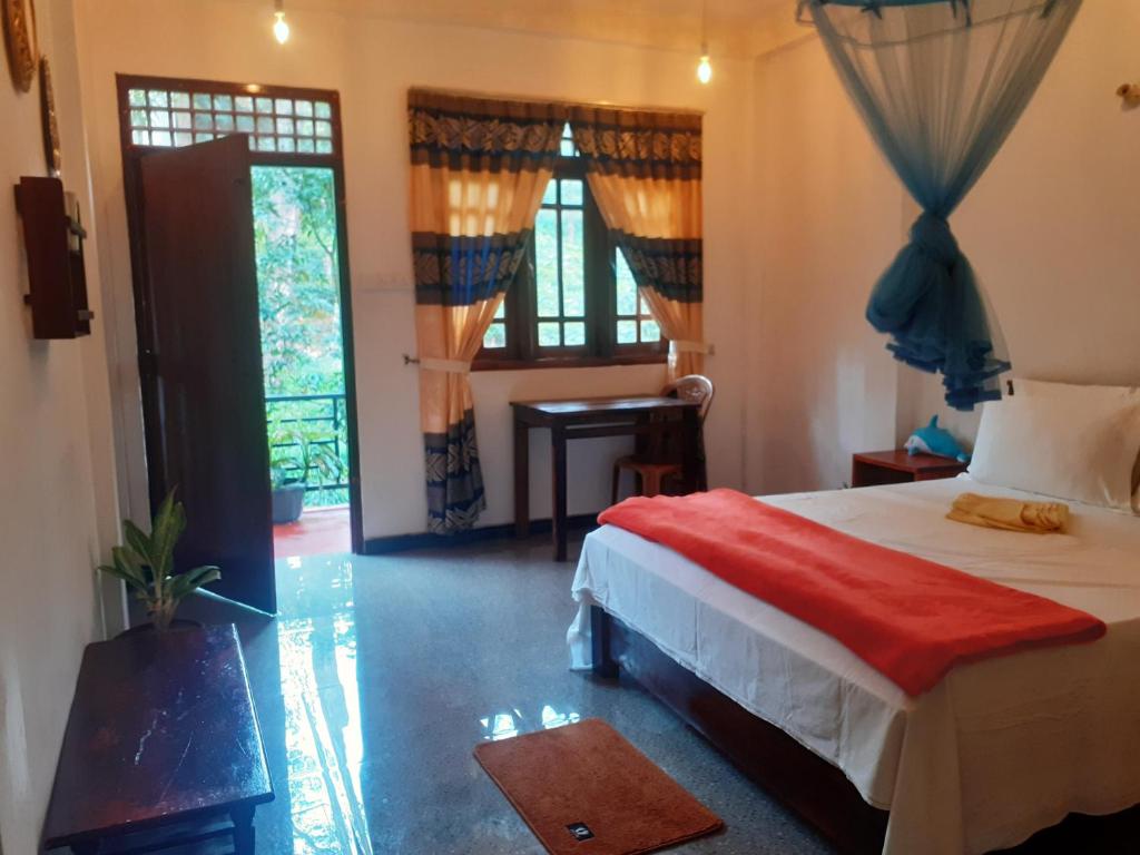 a bedroom with a bed and a door with a window at Daresh home stay in Maskeliya