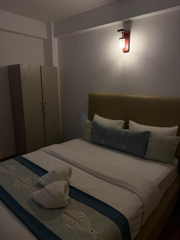 a bedroom with a large bed with a light on it at Nomentano Blue -Luxury Apartments- in Nuwara Eliya