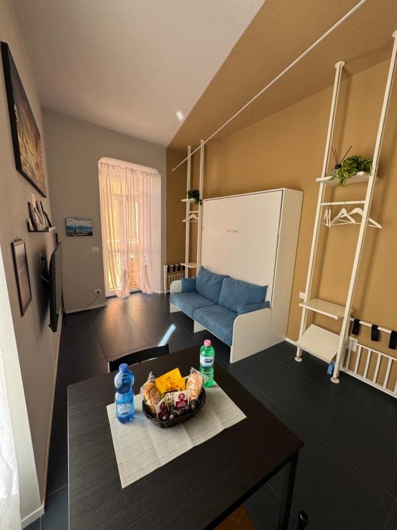 a living room with a table and a blue couch at Vicolo Muratori 1 in Moncalieri