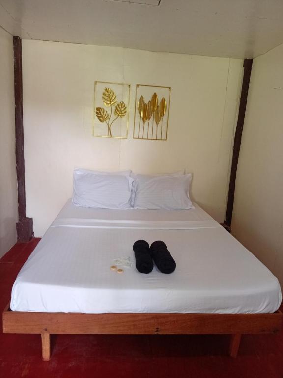 een bed met twee paar schoenen erop bij Kubo ni klay in San Isidro