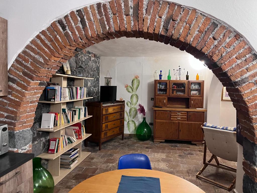 einen Torbogen in einem Zimmer mit einem Tisch und Stühlen in der Unterkunft POGGIO ROSETO in Randazzo