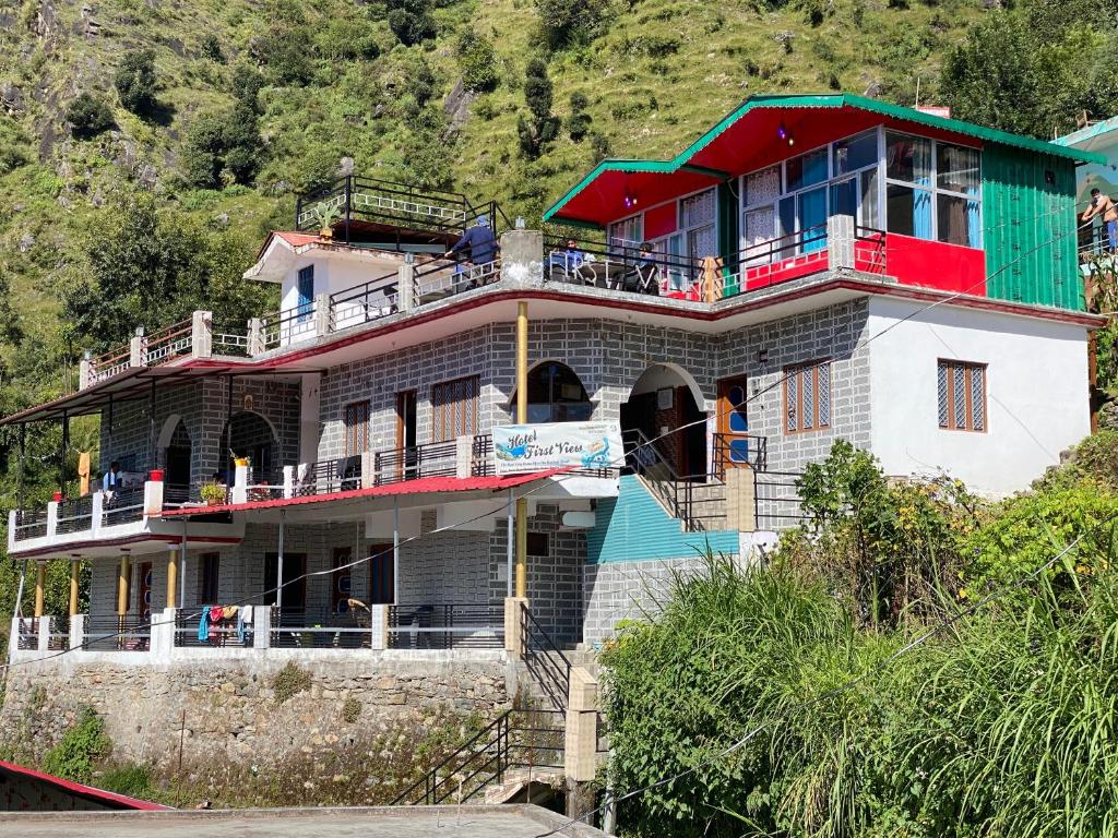 una casa en una colina con techo verde en hotel first view, en Chopta