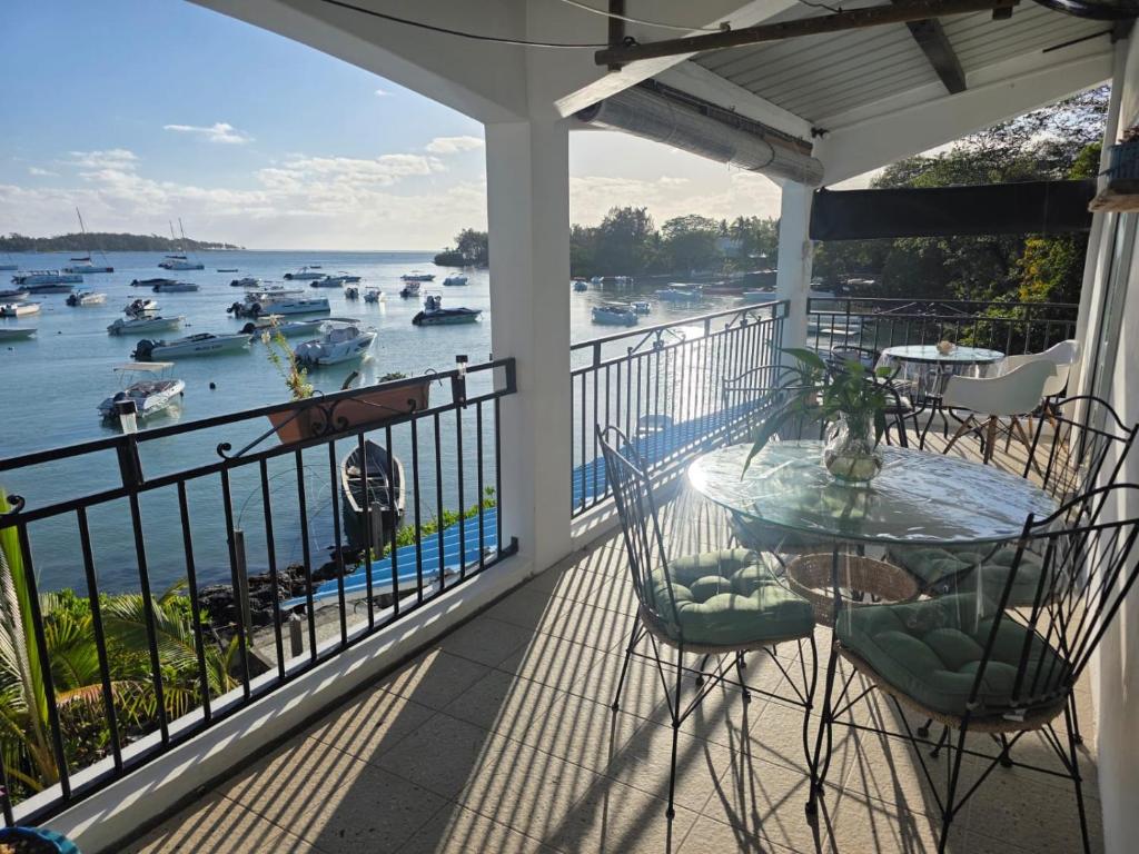a balcony with a table and chairs and a view of the water at Kreolia Blue-Waters in Trou d'Eau Douce