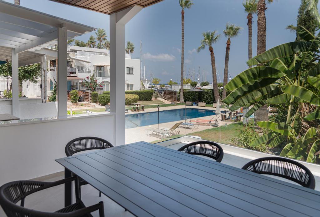 a table on the balcony with a view of the pool at Avyra Residences Chrysakama Sea View in Polis Chrysochous