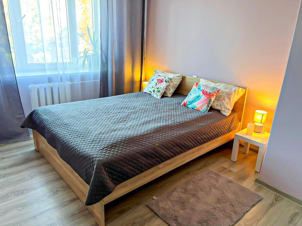 a bedroom with a bed with pillows and a window at Sigulda's Laimas Apartment Self-Check in in Sigulda