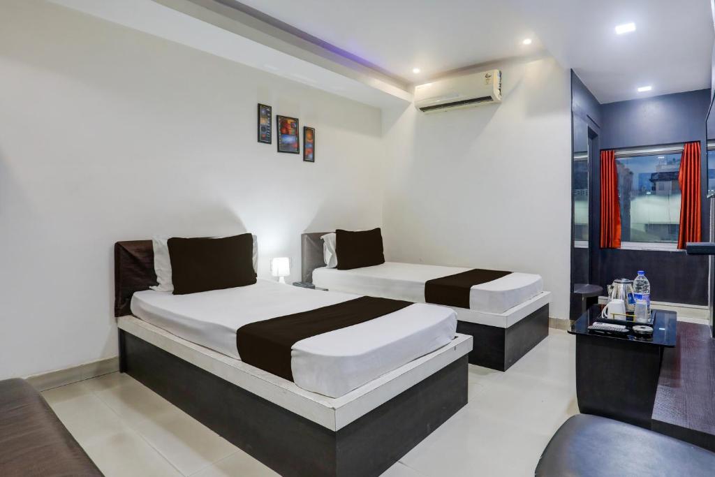 Un dormitorio con dos camas en una habitación. en Collection O Bank More Dhanbad Formerly Hotel Sri Ganesh Ji, en Dhanbād