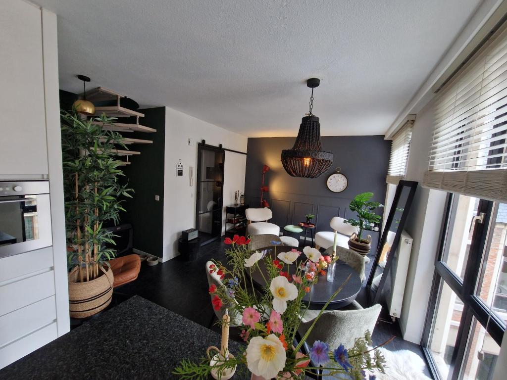 a living room with a table with flowers on it at Appartement historisch centrum Antwerpen in Antwerp