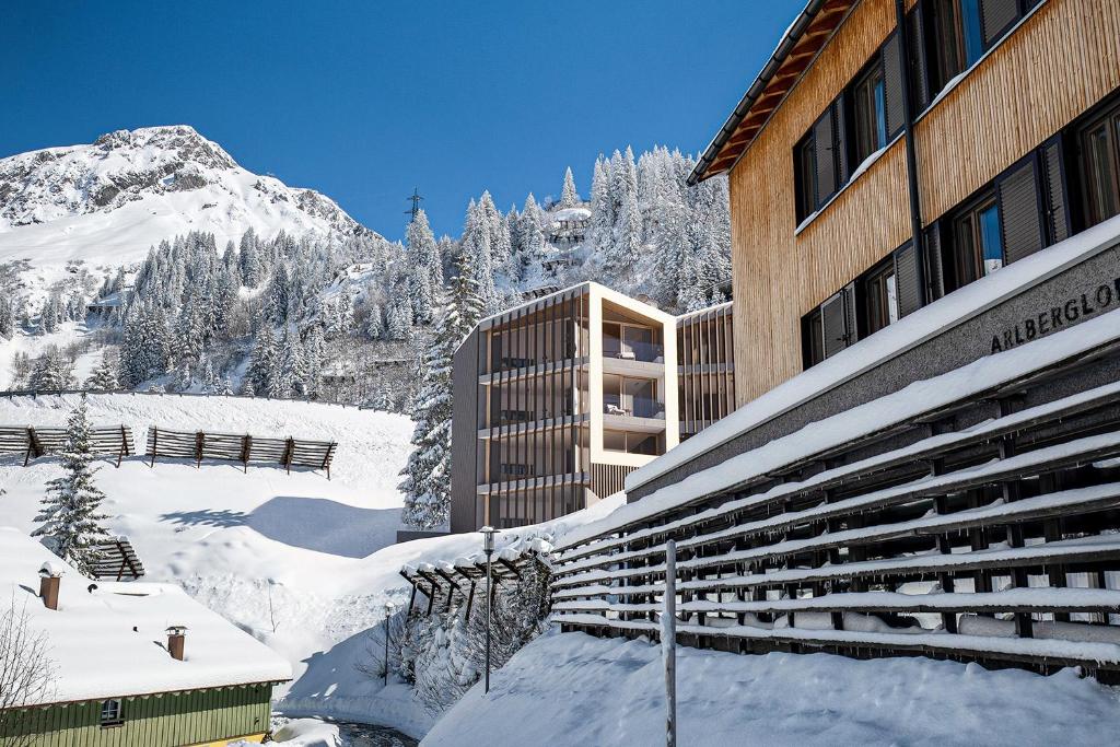 a snow covered building with a mountain in the background at Nexus Suiten - by A-Appartments in Stuben am Arlberg
