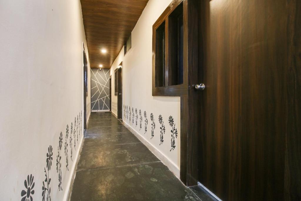 un couloir avec une porte et un sol carrelé dans l'établissement Super Hotel O Sawariya Regency, à Bhopal