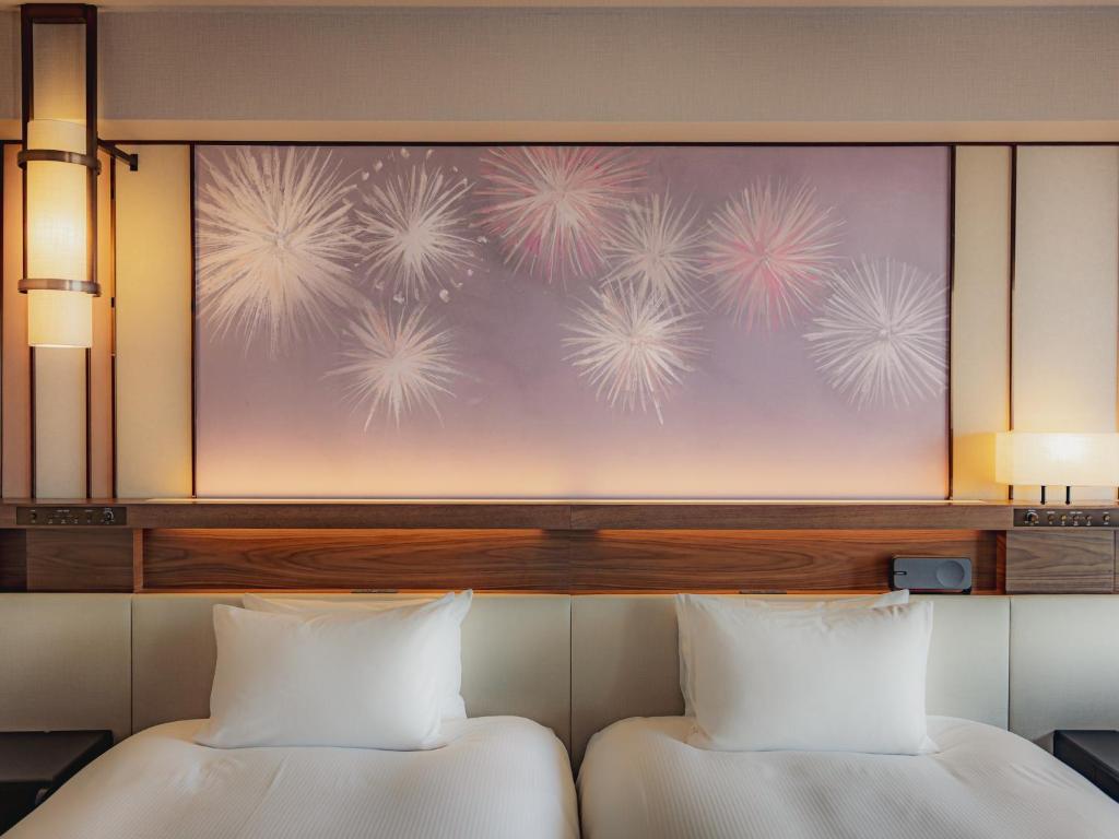 two beds in a room with a painting of dandelions at Asakusa View Hotel in Tokyo