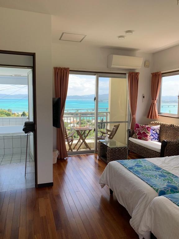 a bedroom with a bed and a view of the ocean at シーブリーズ古宇利 in Nakijin