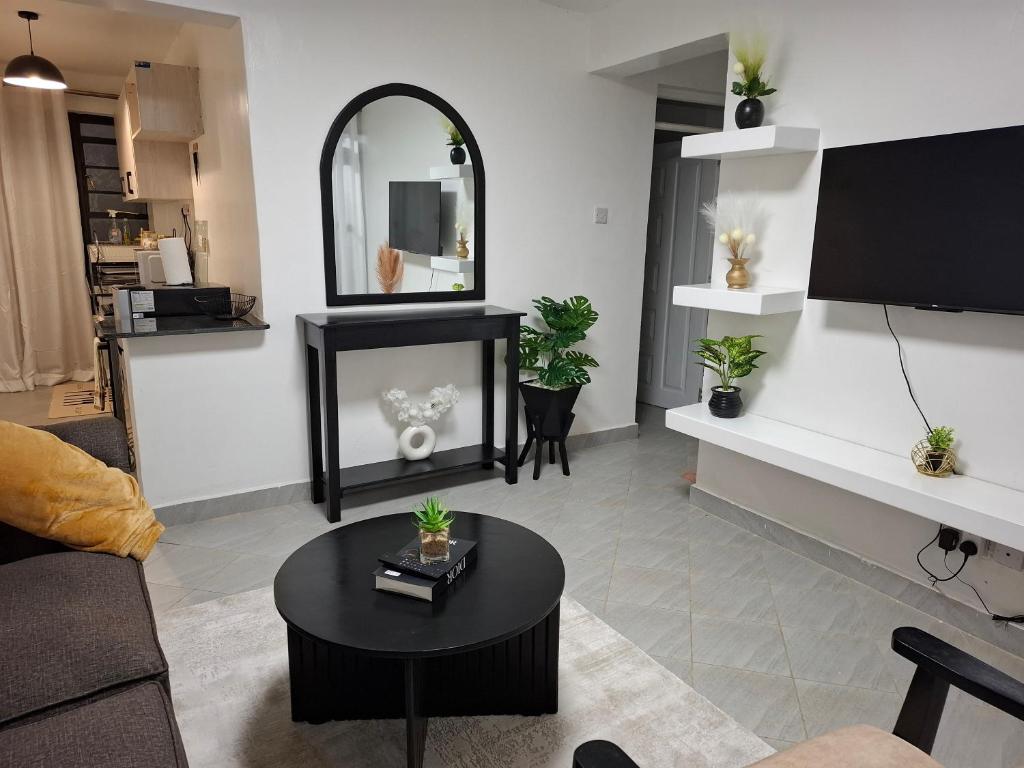 a living room with a table and a mirror at Kari Cozy Homes in Nairobi