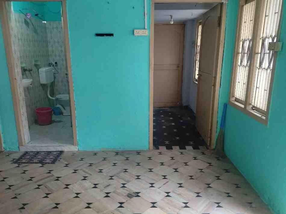 ein Badezimmer mit blauer Tür und gefliestem Boden in der Unterkunft Sri Kanakadhara Vididhillu in Vijayawāda