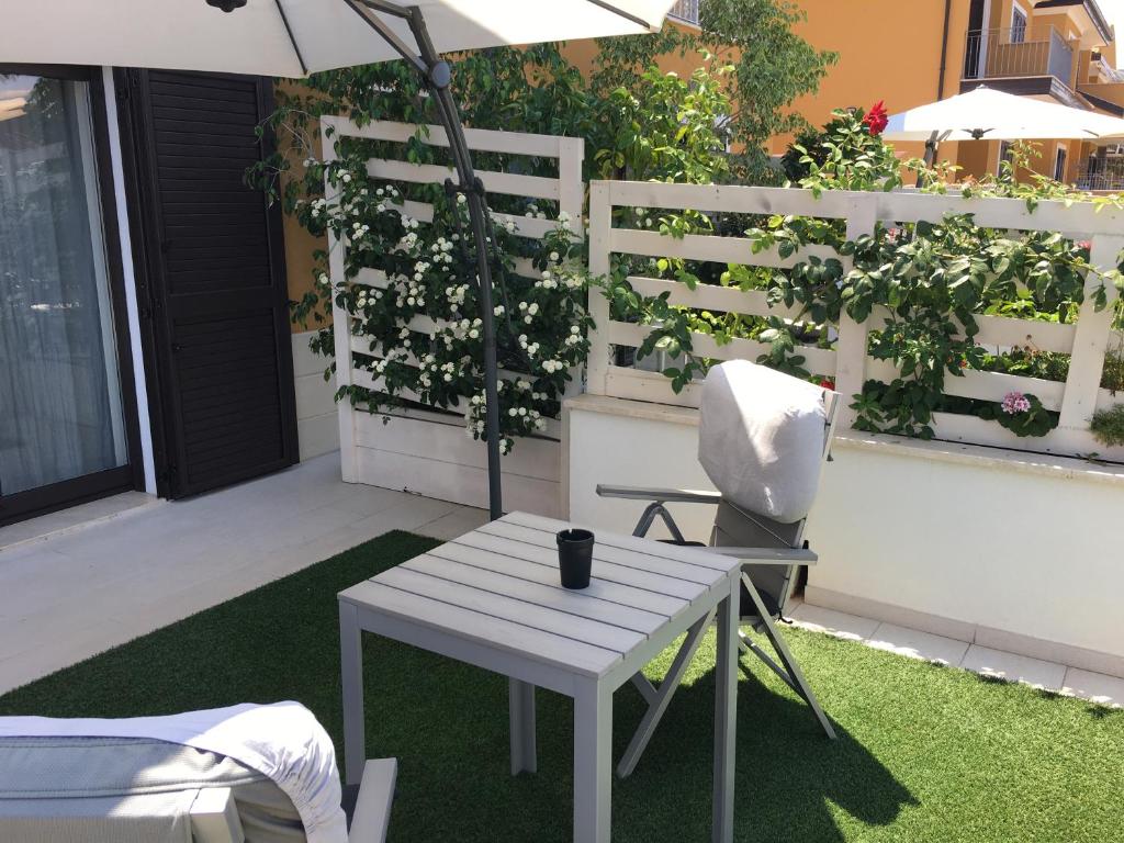 a patio with a table and a chair and an umbrella at Residenza RoMa in Tropea