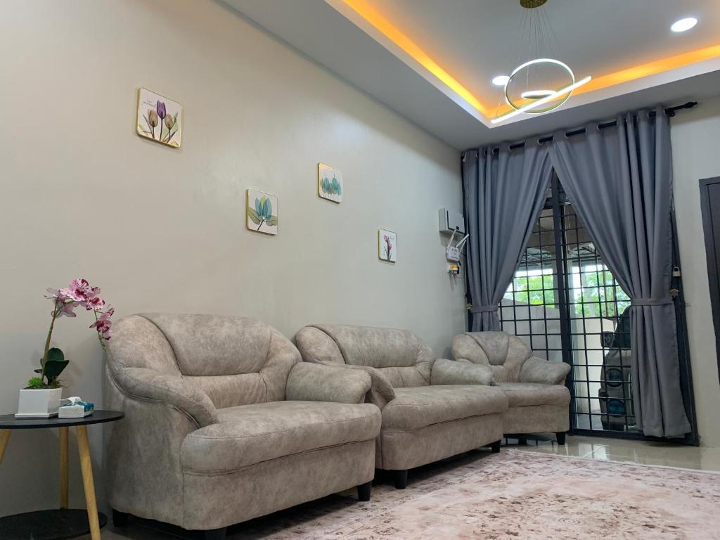 a living room with two couches and a table at De Suria Homestay Jitra in Jitra