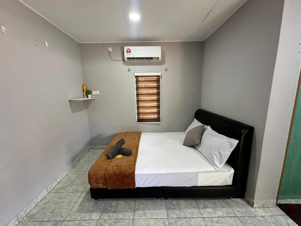 een slaapkamer met een bed met witte lakens en een raam bij Soyak Senja Roomstay in Langkawi Intl