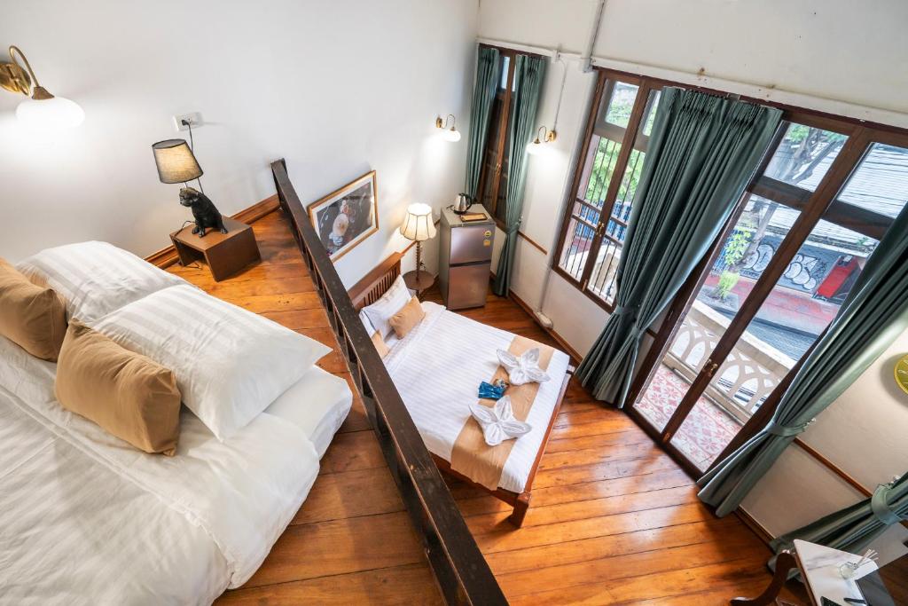 a living room with a large bed and windows at Arun Sa Wad 103 NaNa in Bangkok