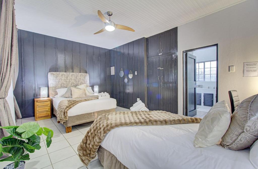 a bedroom with two beds and a ceiling fan at Spacious Valkyrie One-bedroom in Centurion