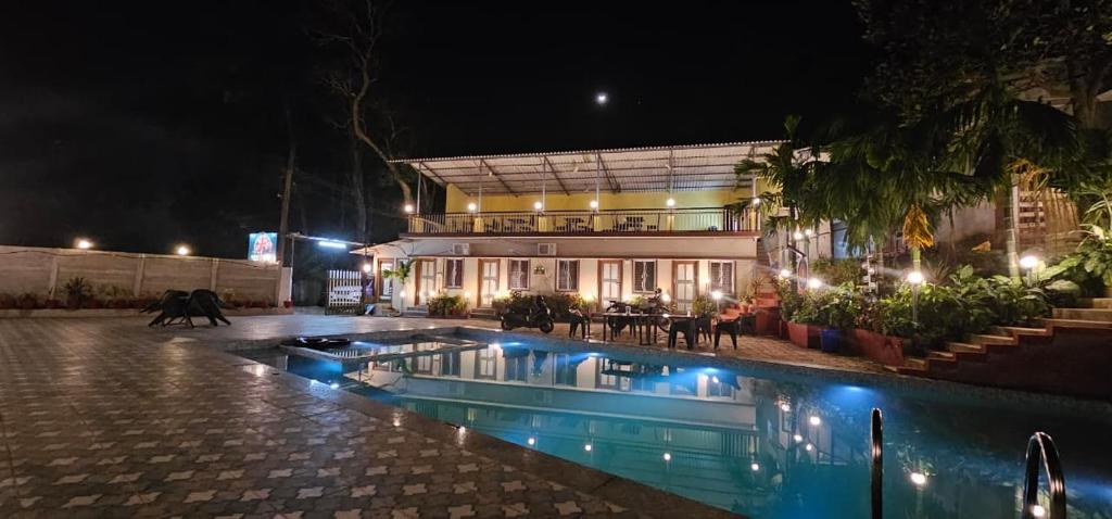 a house with a swimming pool at night at kali river view in Dandeli