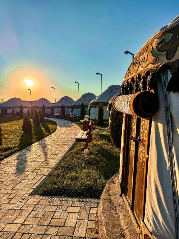 a door to a building with the sunset in the background at Ethnochill Karakol yurt camping in Karakol