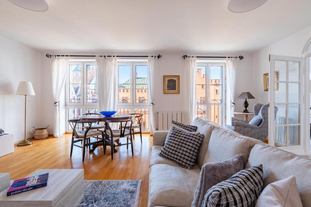 a living room with a couch and a table at Horyzont Apartamenty- Apartament Ratuszowy- stylowy apartament w samym sercu starówki in Kołobrzeg