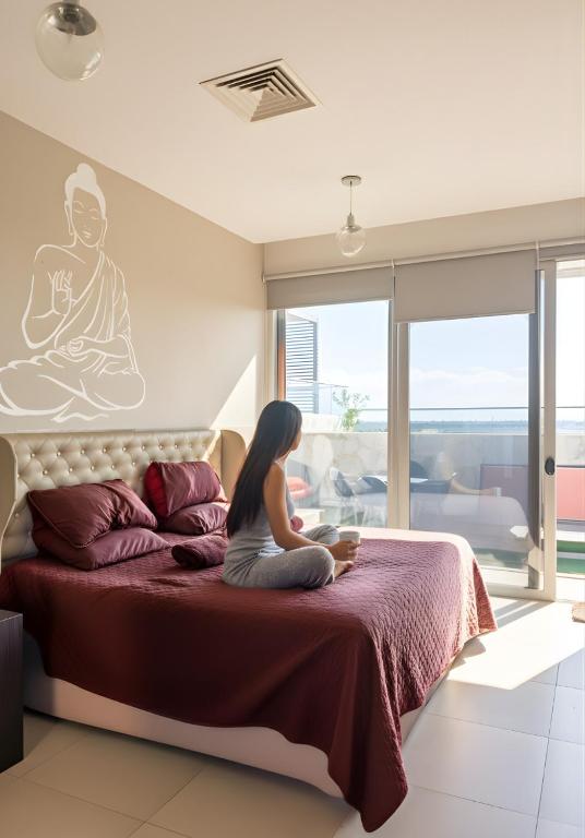 a woman sitting on a bed in a room at Casa Buddha - Pool, Jacuzzi and private terrace in Cancún