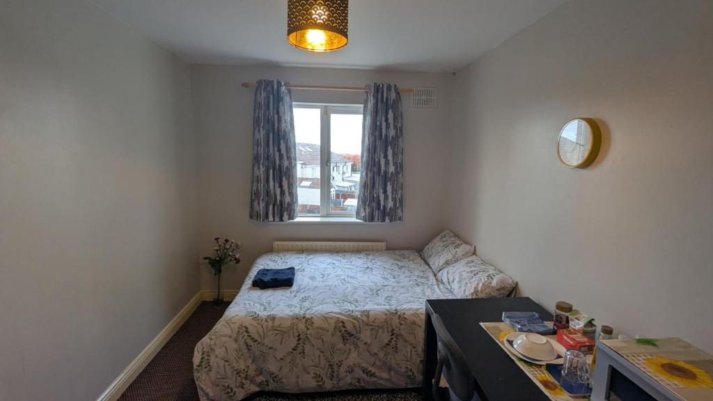 a small bedroom with a bed and a window at Cosy Double Private Room Near Dublin Airport in Swords