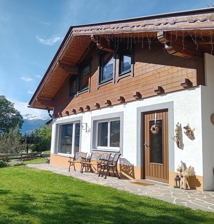 een huis met een patio en stoelen ervoor bij Ferienhaus Herrenschmiede in Obervellach
