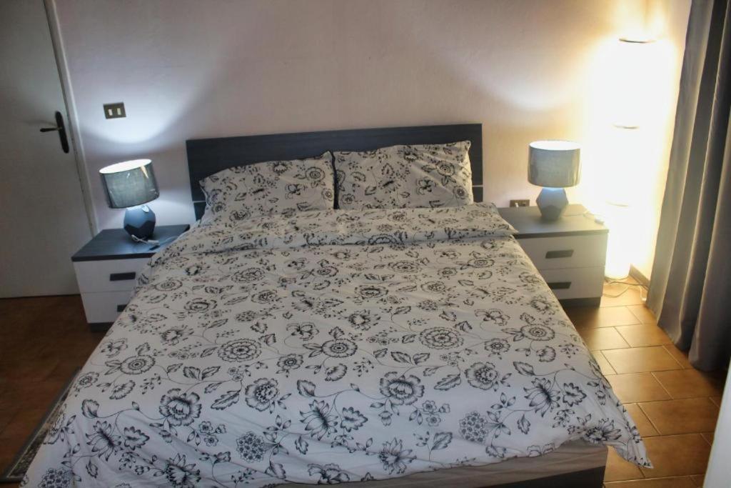 a bed in a bedroom with two night stands and two lamps at La Stazione #1 in Pontedera