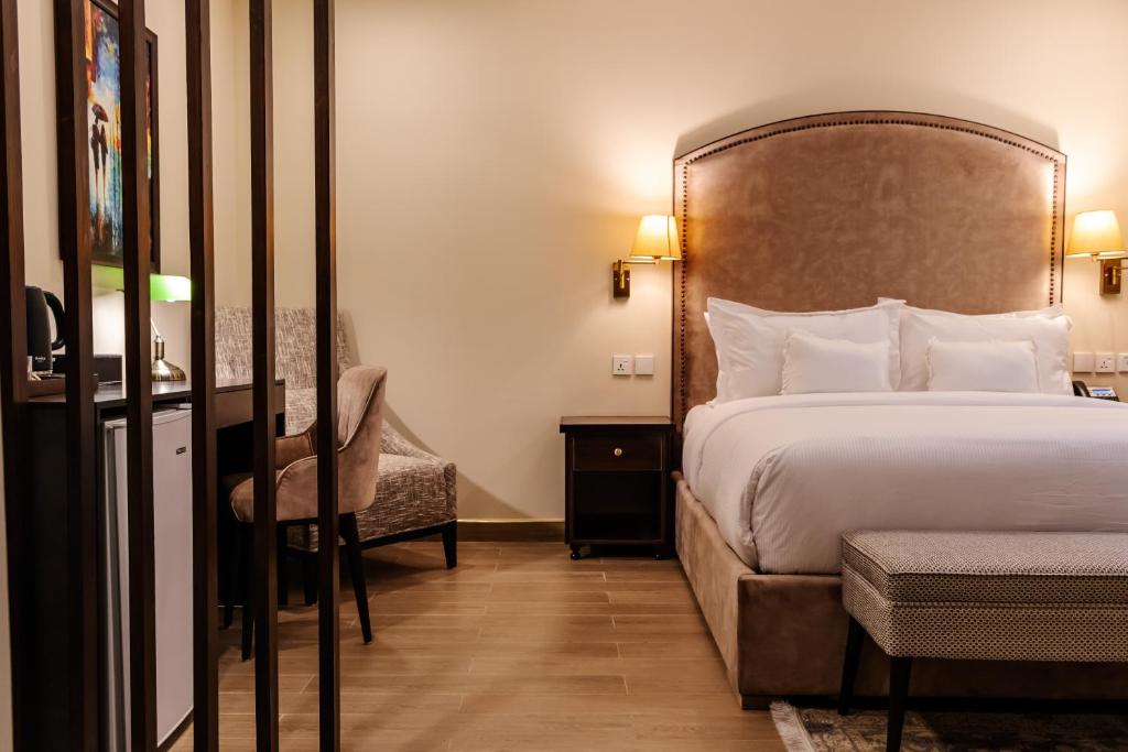 une chambre avec un lit, un bureau et une chaise dans l'établissement Chirani Signature Hotel, à Islamabad