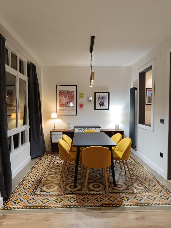 ein Esszimmer mit einem Tisch und gelben Stühlen in der Unterkunft Piso Carpio, 22 by pisoschulospuntoes in León